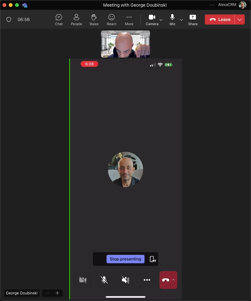 Screenshot of a Microsoft Teams meeting with George Doubinski, showing a mirrored iPhone screen within the meeting window. The iPhone screen displays George Doubinski's profile picture and a 'Stop presenting' button at the bottom. The top part of the screen shows George's video feed in a small window, along with the meeting controls such as Chat, People, Raise, React, More, Camera, Mic, and Share.